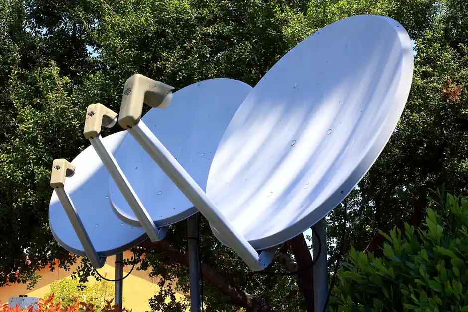 Satellite dishes in nature setting, emphasizing technology blend with environment.